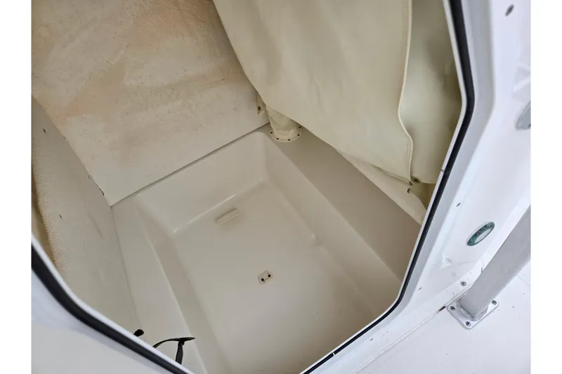 Slide: The Image of Interior storage compartment of 2012 Sea Hunt Ultra 234 boat, featuring clean, white finish. - 23