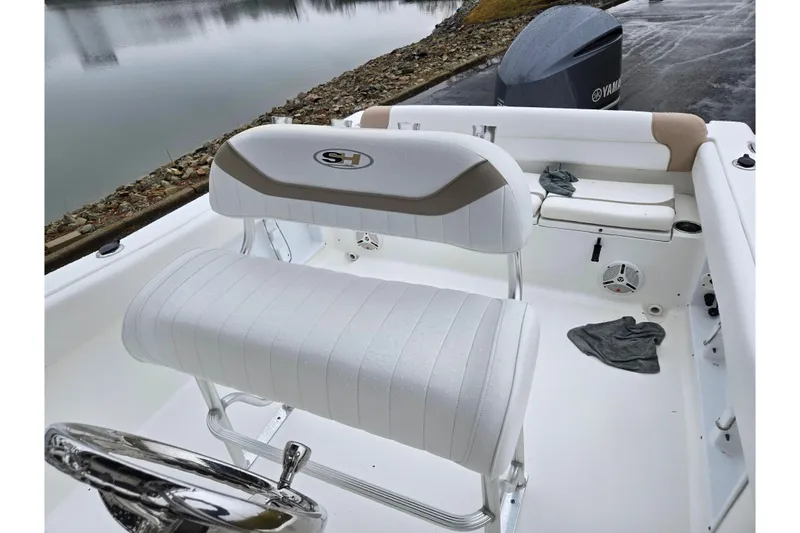 Slide: The Image of 2012 Sea Hunt Ultra 234 boat interior with white seating and Yamaha engine. - 24