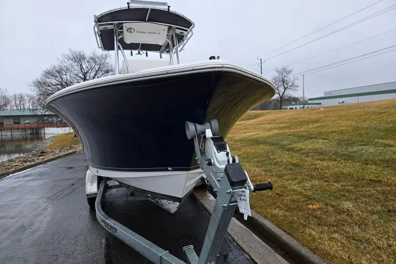 Slide: The Image of 2012 Sea Hunt Ultra 234 boat on trailer, parked near a grassy area. - 6