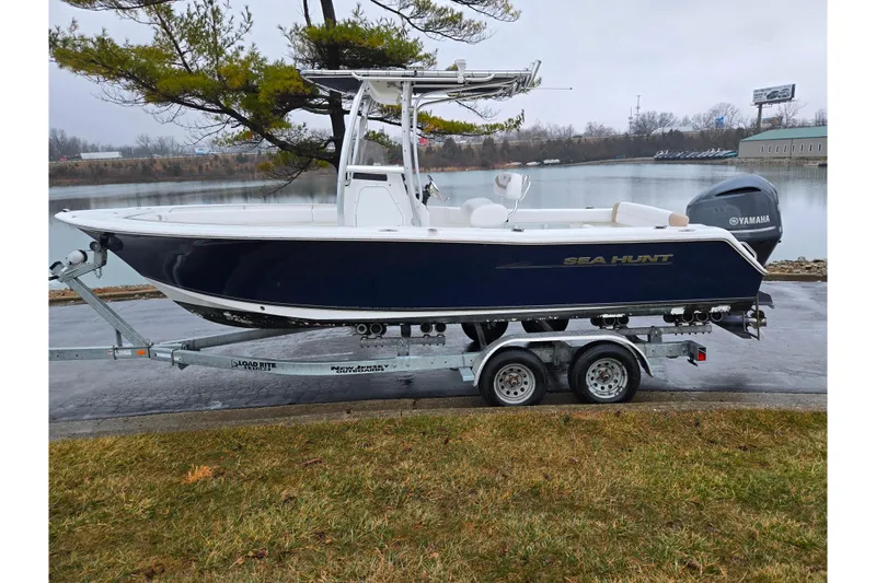 Slide: The Image of 2012 Sea Hunt Ultra 234 boat on trailer by a lake, overcast day. - 9