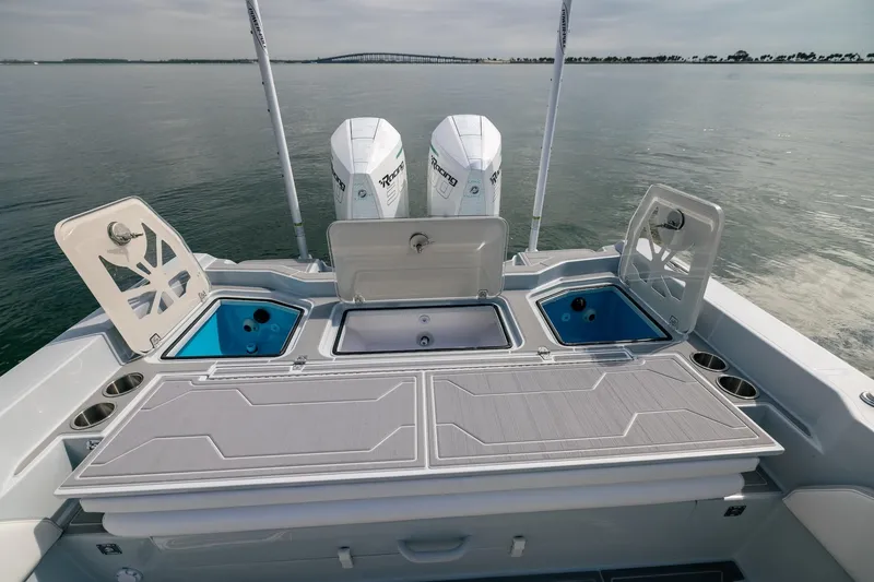 Slide: The Image of 2024 Dynamic D-305DF boat with dual engines and open storage compartments on calm water. - 12