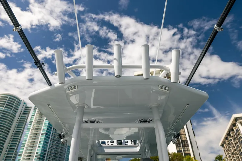 Slide: The Image of 2024 Dynamic D-305DF boat with rod holders, skyscrapers, and blue sky background. - 21