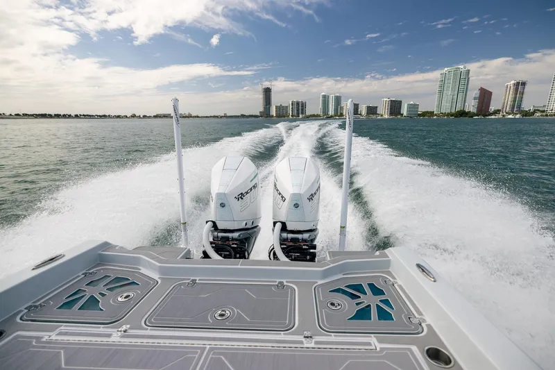Slide: The Image of Dynamic D-305DF 2024 boat cruising on water with city skyline in background. - 22