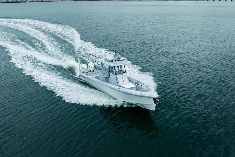 Slide: The Image of 2024 Dynamic D-305DF boat cruising on open water, creating a wake. - 3