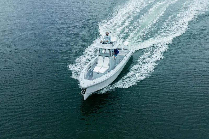 Slide: The Image of 2024 Dynamic D-305DF boat cruising on open water, creating a wake. - 4