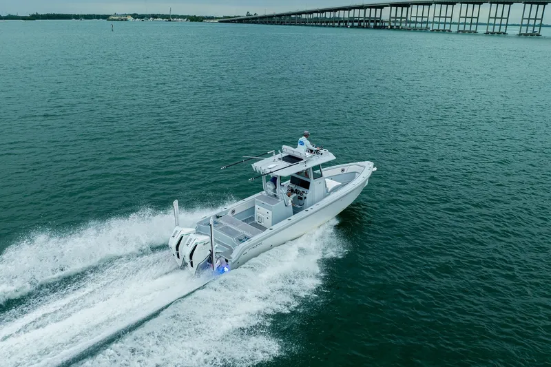 Slide: The Image of 2024 Dynamic D-305DF boat cruising on open water near a long bridge. - 6