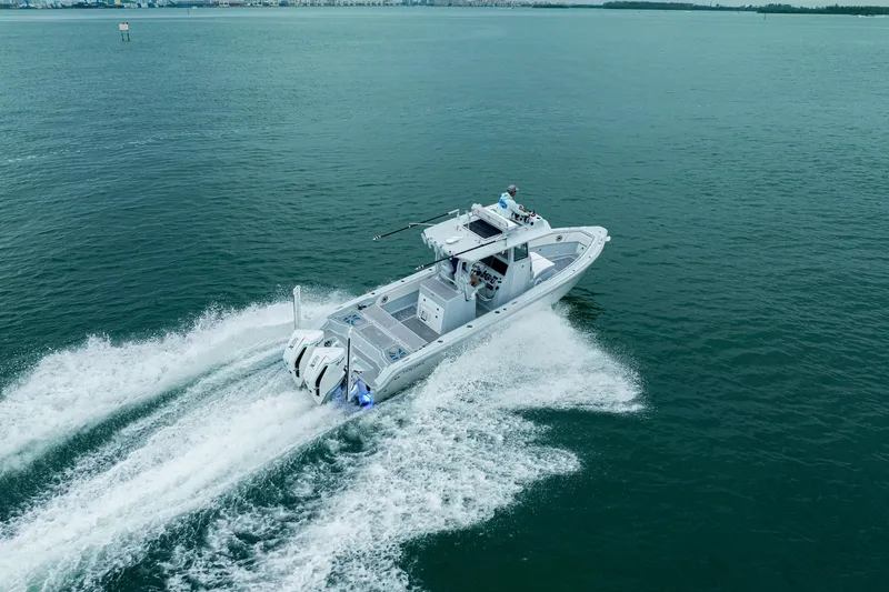 Slide: The Image of 2024 Dynamic D-305DF boat cruising on open water, creating a wake. - 7