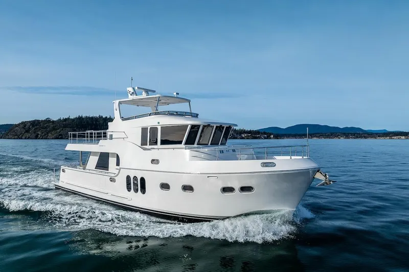 Slide: The Image of 2024 Northwest 55 yacht cruising on calm waters with scenic background. - 1