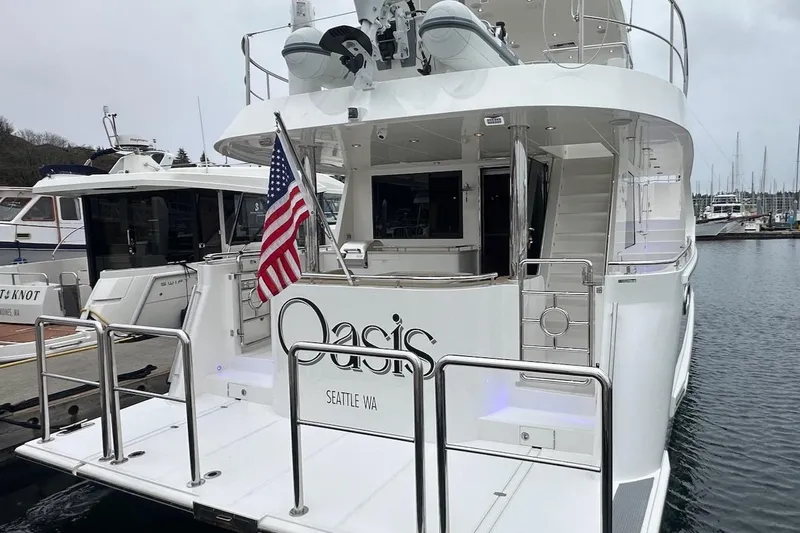 Slide: The Image of Luxury Northwest 55 yacht, 2024 model, docked with American flag, Seattle marina. - 10