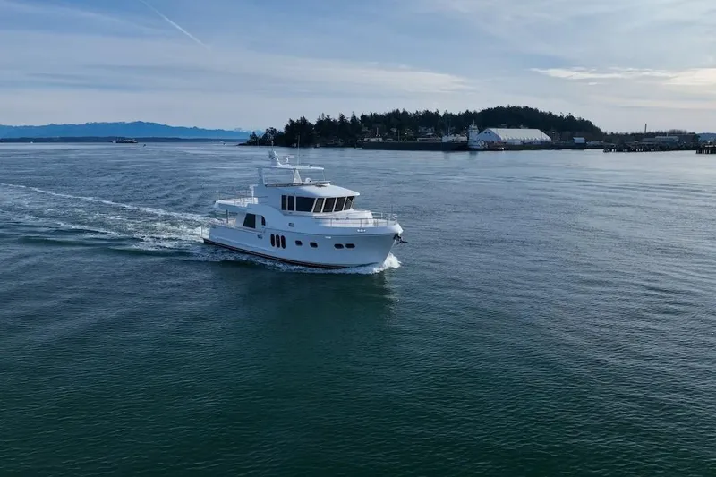 Slide: The Image of 2024 Northwest 55 yacht cruising on calm waters near a scenic coastline. - 101