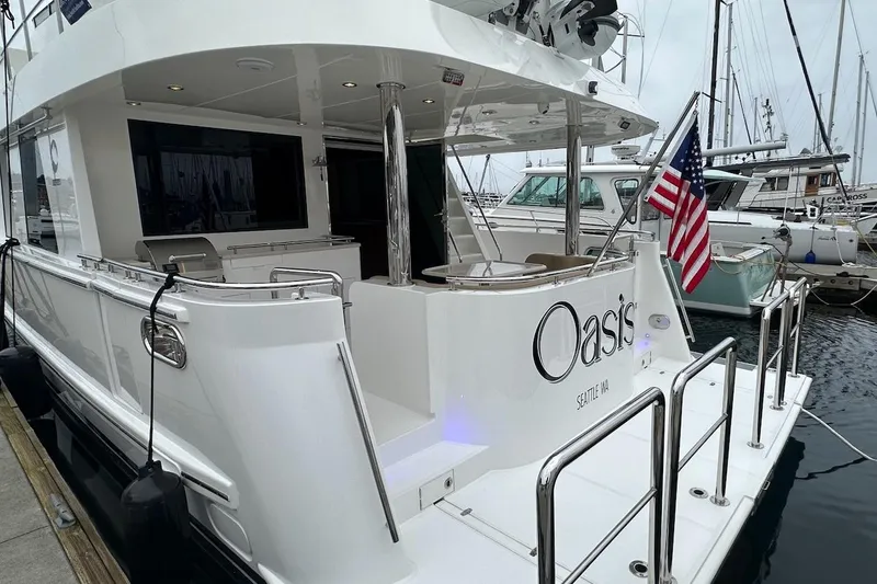 Slide: The Image of Luxury Northwest 55 yacht "Oasis" docked, featuring sleek design and American flag. - 13