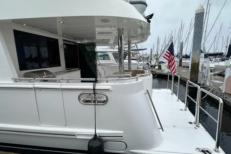 Slide: The Image of Luxury Northwest 55 yacht docked at marina, featuring sleek design and American flag. - 14