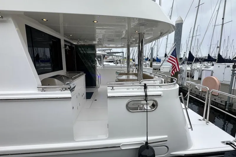 Slide: The Image of Luxury yacht Northwest 55, 2024 model, docked with American flag, sleek design. - 15