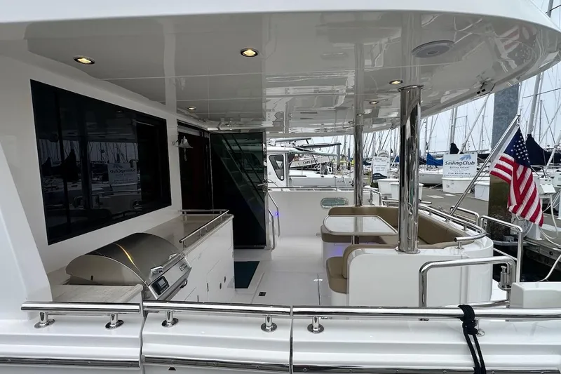 Slide: The Image of Luxury yacht deck with seating and grill, Northwest 55, 2024 model, docked at marina. - 16