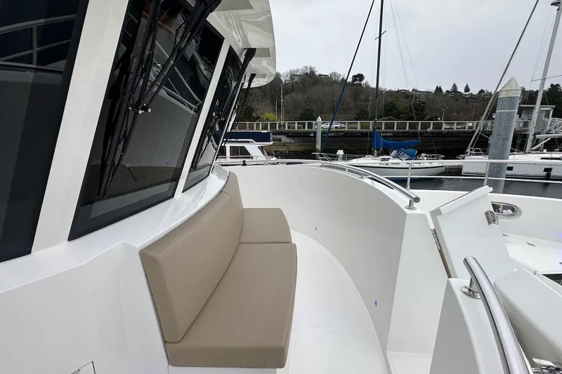 Slide: The Image of 2024 Northwest 55 yacht with beige seating, docked at a marina. - 28