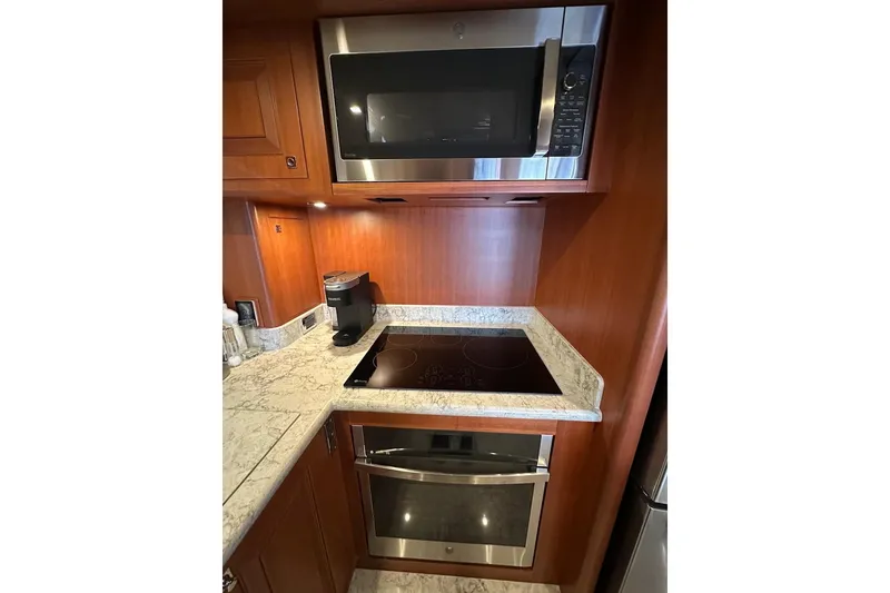 Slide: The Image of Modern kitchen with microwave, induction cooktop, and oven in a Northwest 55, 2024 model. - 41