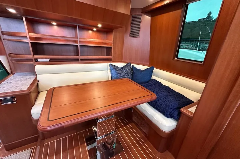 Slide: The Image of Luxurious 2024 Northwest 55 yacht interior with wood finish, dining area, and cozy seating. - 49