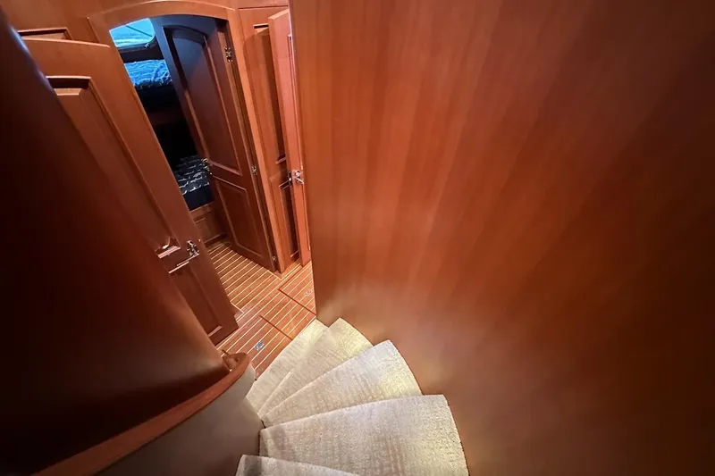 Slide: The Image of Curved staircase in 2024 Northwest 55 yacht interior with wooden finish. - 54