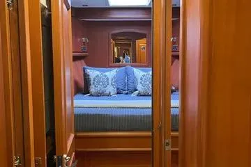 Slide: The Image of Luxurious cabin interior of 2024 Northwest 55 yacht with elegant bedding and wood finish. - 55