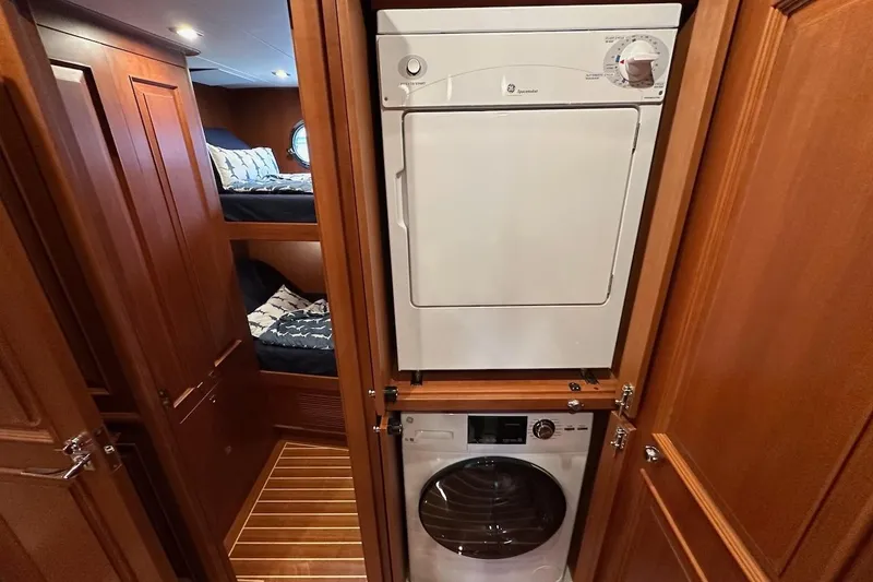 Slide: The Image of Laundry area with stacked washer and dryer in 2024 Northwest 55 yacht interior. - 62