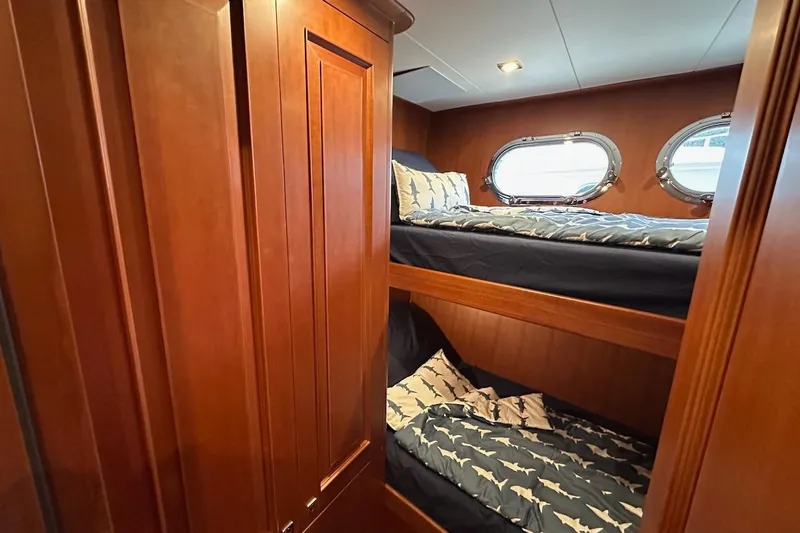 Slide: The Image of Cozy bunk beds in 2024 Northwest 55 yacht cabin with wooden interior and porthole windows. - 63