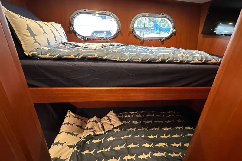 Slide: The Image of Bunk beds with shark-themed bedding in a 2024 Northwest 55 yacht cabin. - 64