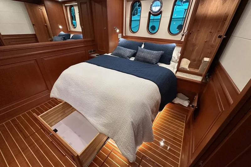 Slide: The Image of Luxurious Northwest 55 yacht bedroom with wood paneling and elegant bedding, 2024 model. - 68