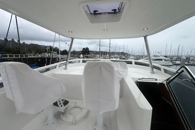 Slide: The Image of Flybridge of 2024 Northwest 55 yacht with covered seats, marina view. - 78