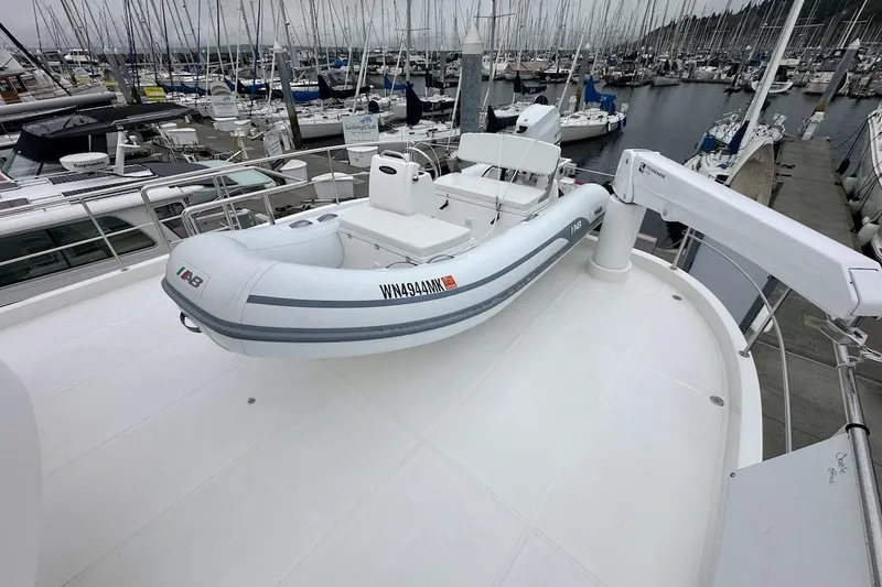 Slide: The Image of Rooftop view of a 2024 Northwest 55 yacht with an inflatable boat at a marina. - 88