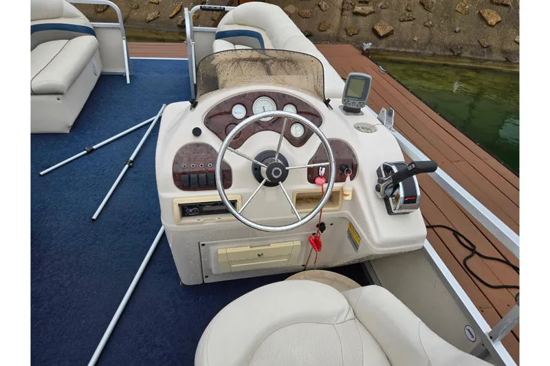 Slide: The Image of 2005 Manitou 20 Oasis boat dashboard with steering wheel and controls. - 18