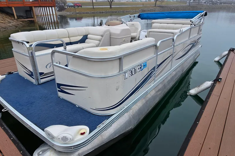 Slide: The Image of 2005 Manitou 20 Oasis pontoon boat docked on calm water. - 5