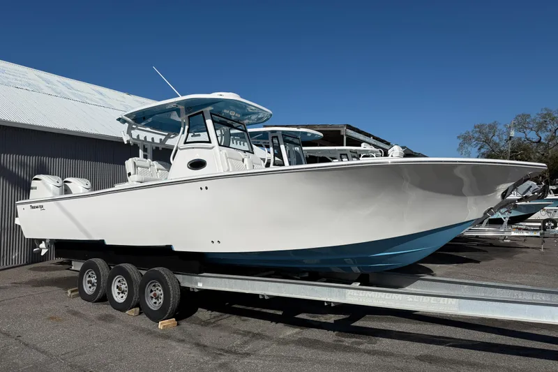 The Image of 2026 Tidewater 3100 Carolina Bay boat on trailer, displayed outdoors under clear blue sky. - 1