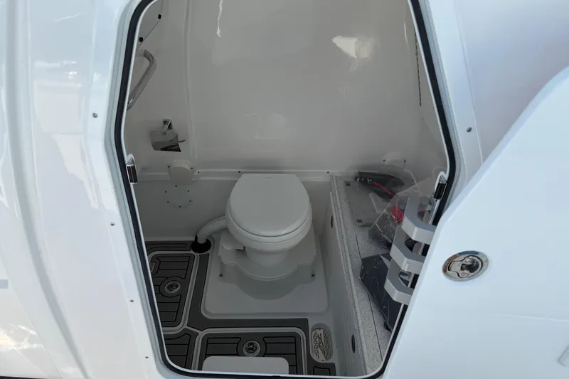 Slide: The Image of 2026 Tidewater 3100 Carolina Bay boat interior bathroom with toilet and storage. - 10