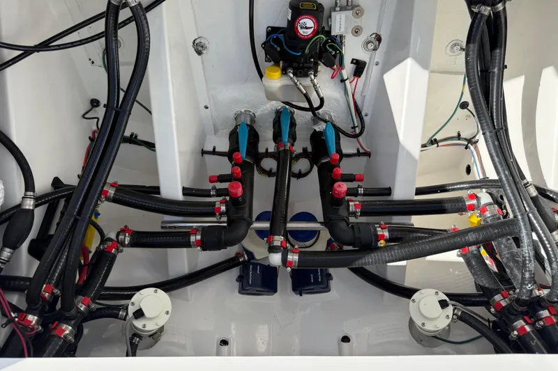 Slide: The Image of Engine compartment of 2026 Tidewater 3100 Carolina Bay boat, showcasing complex wiring and plumbing. - 15