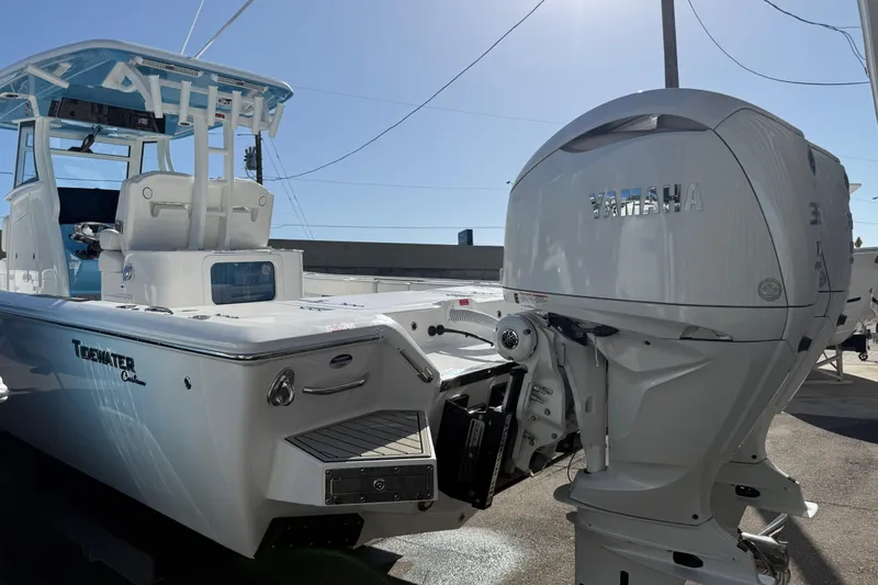 Slide: The Image of 2026 Tidewater 3100 Carolina Bay boat with Yamaha engine, docked under clear sky. - 3
