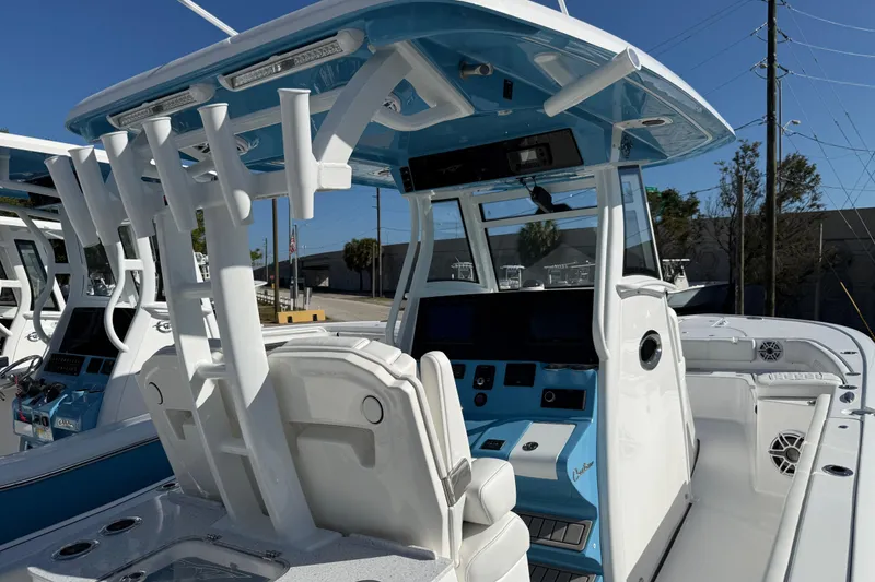 Slide: The Image of 2026 Tidewater 3100 Carolina Bay boat with modern helm and seating, featuring blue and white design. - 5