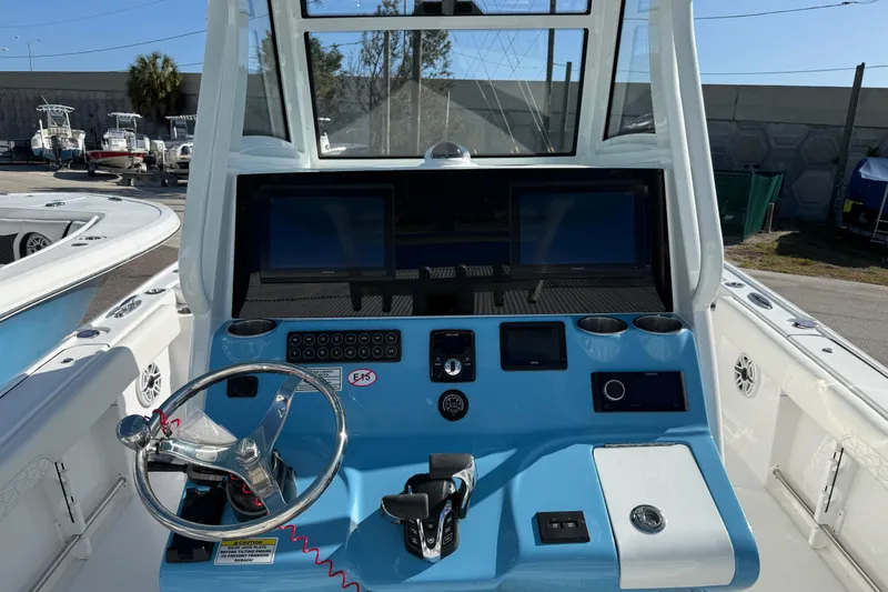 Slide: The Image of 2026 Tidewater 3100 Carolina Bay boat dashboard with steering wheel and electronic displays. - 6