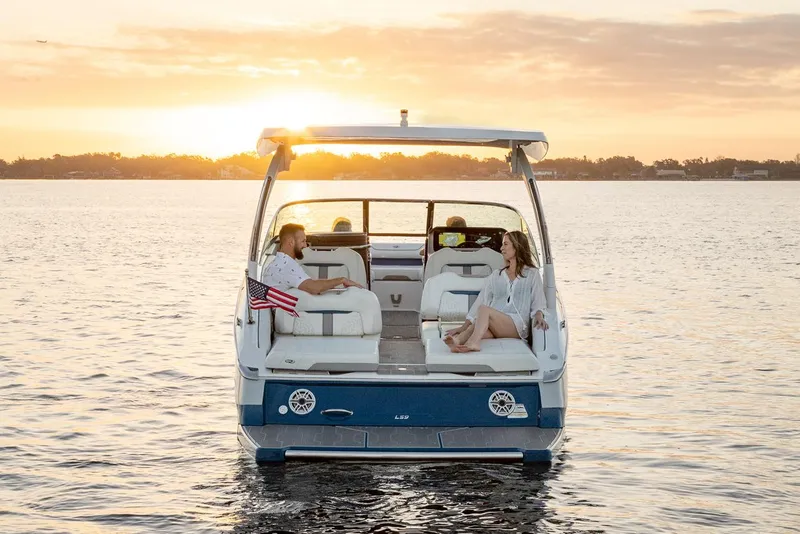 Slide: The Image of 2026 Regal LS9 boat cruising on a serene lake under a clear blue sky. - 2