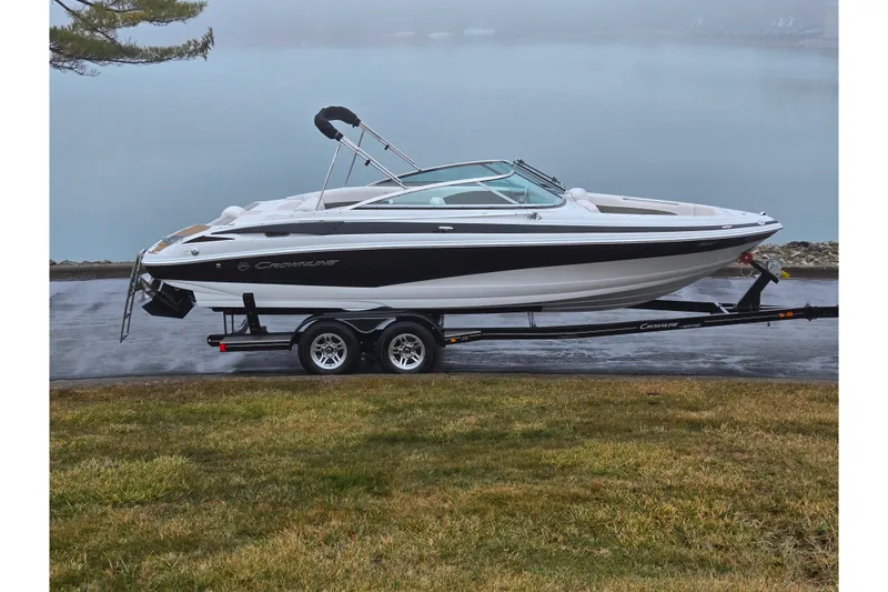 The Image of 2012 Crownline 235 SS boat on trailer by a foggy lake. - 0