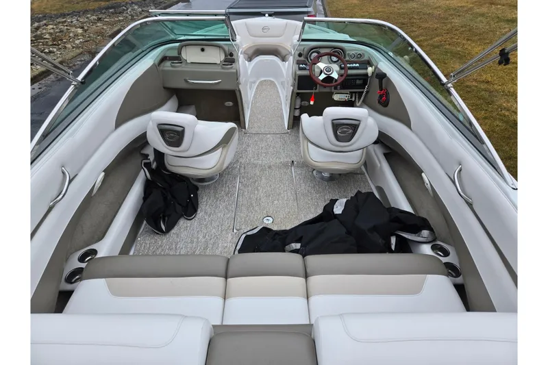 Slide: The Image of 2012 Crownline 235 SS boat interior with beige seating and modern dashboard. - 10