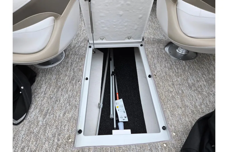 Slide: The Image of 2012 Crownline 235 SS boat interior storage compartment with open hatch and equipment inside. - 13