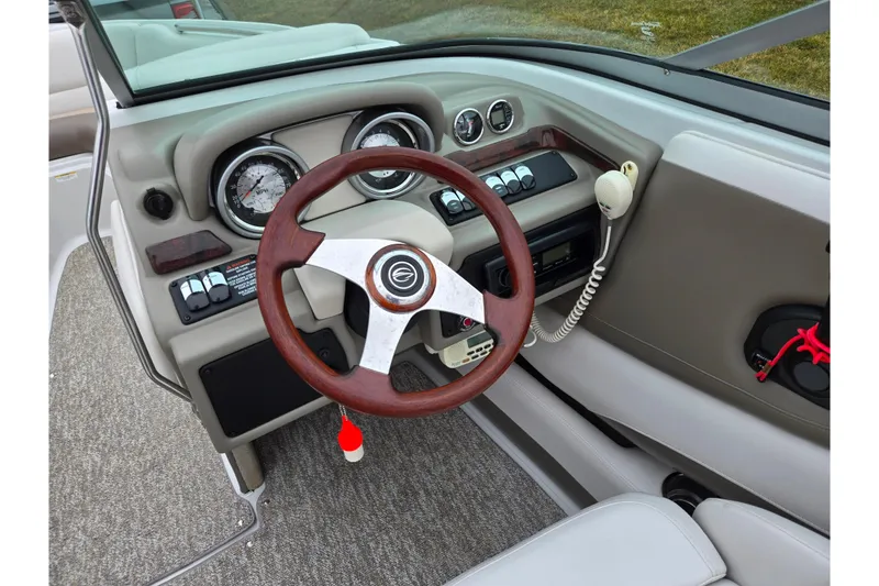 Slide: The Image of 2012 Crownline 235 SS boat dashboard with wood steering wheel and gauges. - 17
