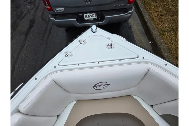 Slide: The Image of 2012 Crownline 235 SS boat bow with white seating, parked near a truck. - 20