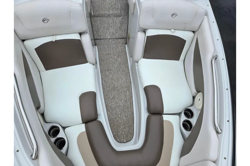 Slide: The Image of 2012 Crownline 235 SS boat interior with beige and white seating, cup holders, and carpeted flooring. - 21