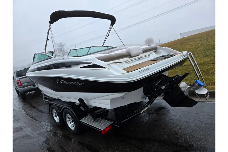 Slide: The Image of 2012 Crownline 235 SS boat on trailer, parked on wet pavement. - 3