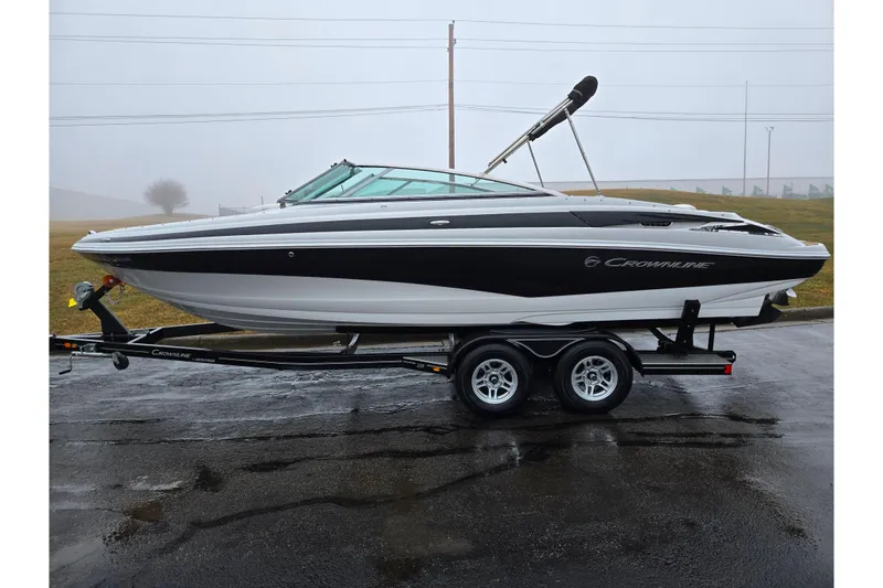 Slide: The Image of 2012 Crownline 235 SS boat on trailer, parked on wet pavement in foggy weather. - 4