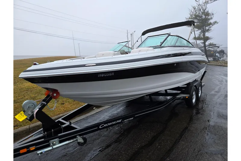 Slide: The Image of 2012 Crownline 235 SS boat on trailer, parked on wet pavement. - 5