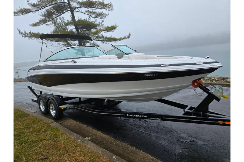 Slide: The Image of 2012 Crownline 235 SS boat on trailer, parked near a foggy lake. - 8