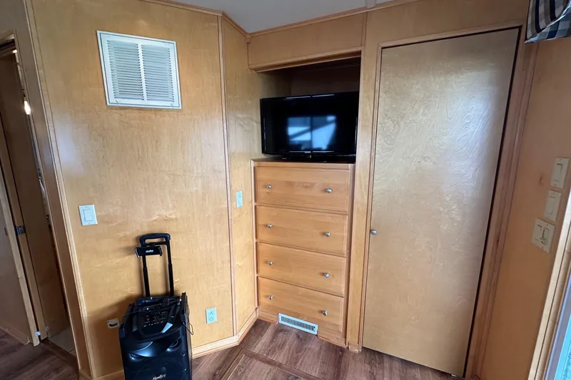 Slide: The Image of Interior of 2005 Sumerset 16x68 houseboat with wooden cabinetry and TV. - 12