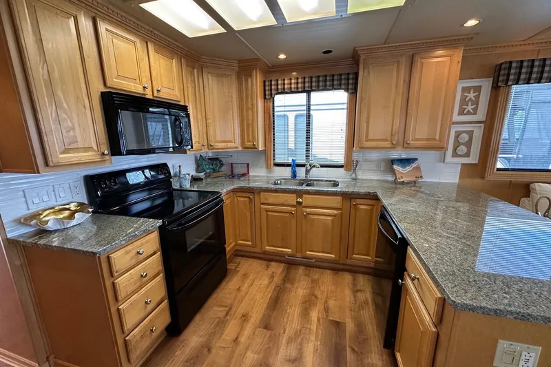 Slide: The Image of Luxurious kitchen in 2005 Sumerset 16x68 houseboat with wooden cabinets and granite countertops. - 4